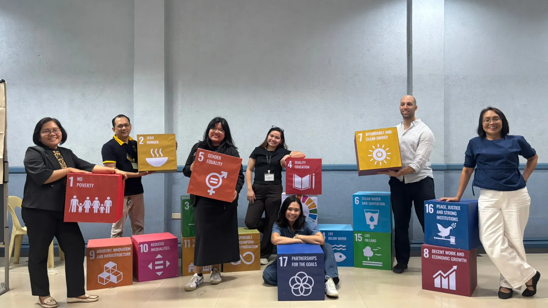 UNO-R faculty and staff holding sustainable development goal cards